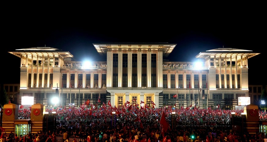 People gather outside the Presidential Palace in Ankara as Turkish President Recep Tayyip Erdogan delivers a speech, on Wednesday, Aug. 10, 2016. Erdogan was addressed crowds that had gathered for the ...