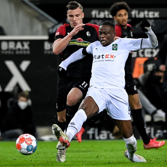 epa09624275 Freiburg's Ermedin Demirovic (L) in action against Moenchengladbach's Denis Zakaria (R) during the German Bundesliga soccer match between Borussia Moenchengladbach and SC Freiburg in Moenchengladbach, Germany, 05 December 2021.  EPA/SASCHA STEINBACH CONDITIONS - ATTENTION: The DFL regulations prohibit any use of photographs as image sequences and/or quasi-video.