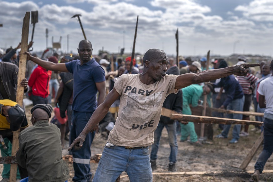 epaselect epa08375776 South African Alex Madikane (C) stands off against City of Cape Town law enforcement officers to try prevent them from demolishing his shack during a land grab by hundreds in Kha ...