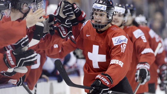 Switzerland forward Nico Hischier (18) celebrates with teammates at the bench after scoring against the United States during the third period of a quarterfinal hockey game at the world junior champion ...