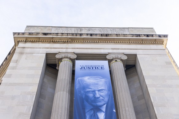 epa12763682 A banner of US President Donald Trump hangs from the side of the Department of Justice (DOJ) in Washington, DC, USA, 20 February 2026. EPA/JIM LO SCALZO