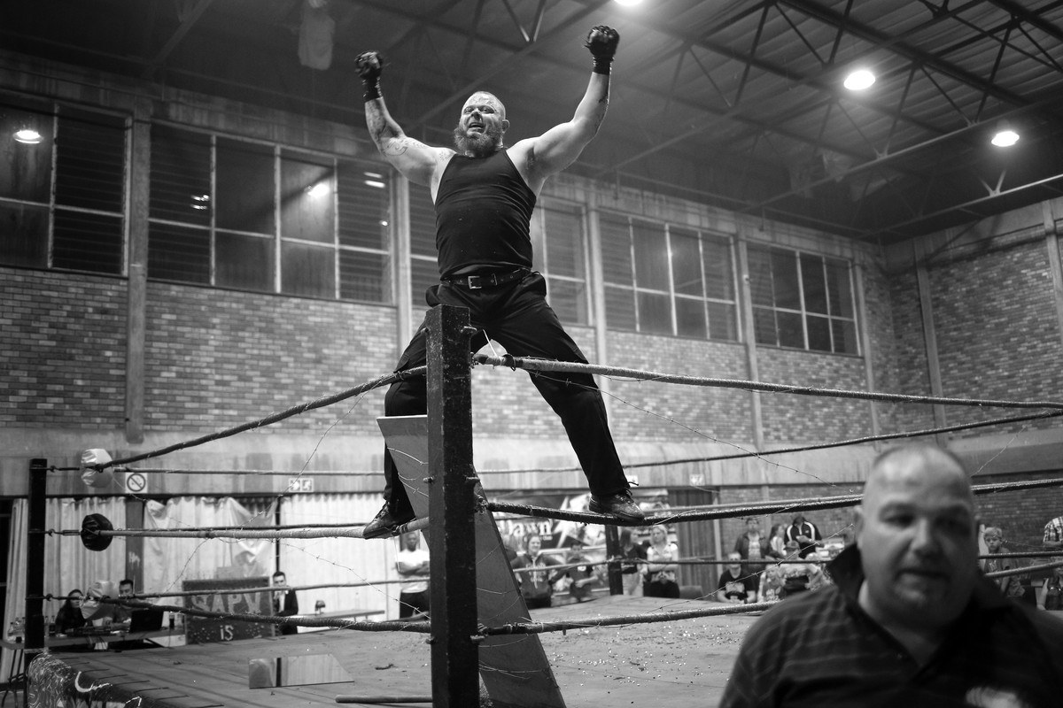 epa05916687 (25/32) Wrestler 'The Jackal' climbs onto the ropes to celebrate beating 'Hector Payne' during a hardcore wrestling match at the Brakpan Community Hall, in Brakpan, Joh ...