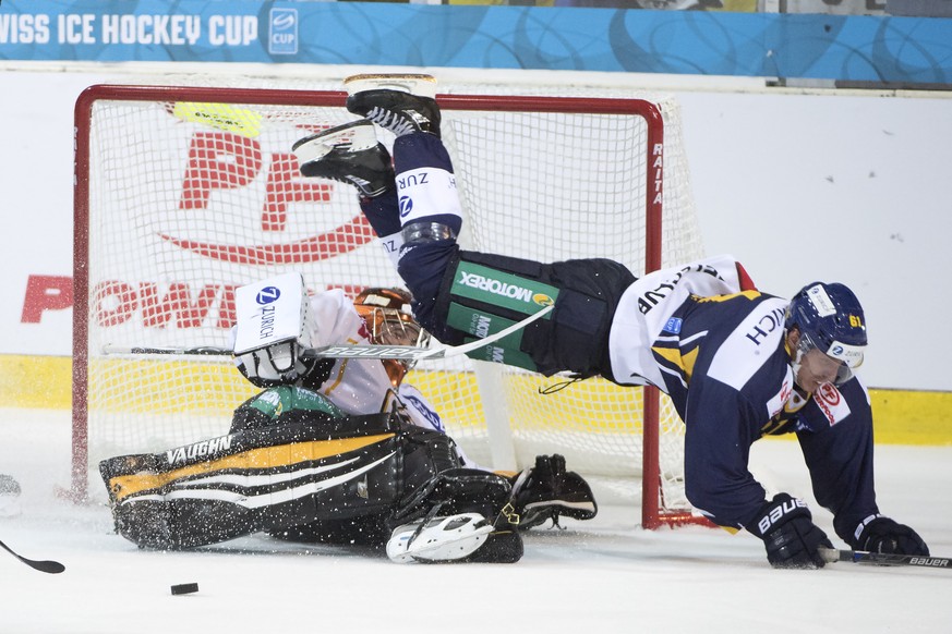 Langenthals Vincenzo Kueng, rechts, im Kampf um den Puck gegen, Luganos Goalie Daniel Manzato, links, im Eishockey Achtelfinal Cupspiel zwischen dem SC Langenthal und dem HC Lugano, am Dienstag, 25. O ...