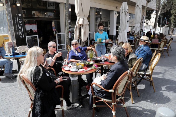 epa09063618 People sit in a re-opened restaurant in downtown Jerusalem, 09 March 2021. Israeli government approved the easing of coronavirus restrictions allowing bars, restaurants, event halls, sport ...