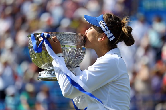 Switzerland's Belinda Bencic kisses the trophy as she celebrates victory in the final against Poland's Agnieszka Radwanska during the women's tennis tournament, Eastbourne, England, Sat ...