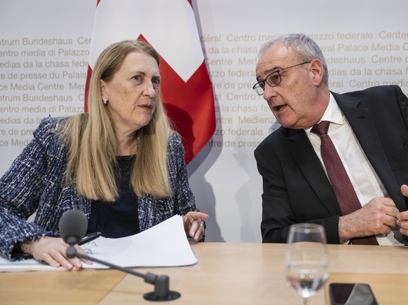 Swiss Federal Councillor Guy Parmelin, right, and Helene Budliger Artieda, State secretary for economy, talk after informing during a press conference on the new import tariffs into the US, Friday, No ...
