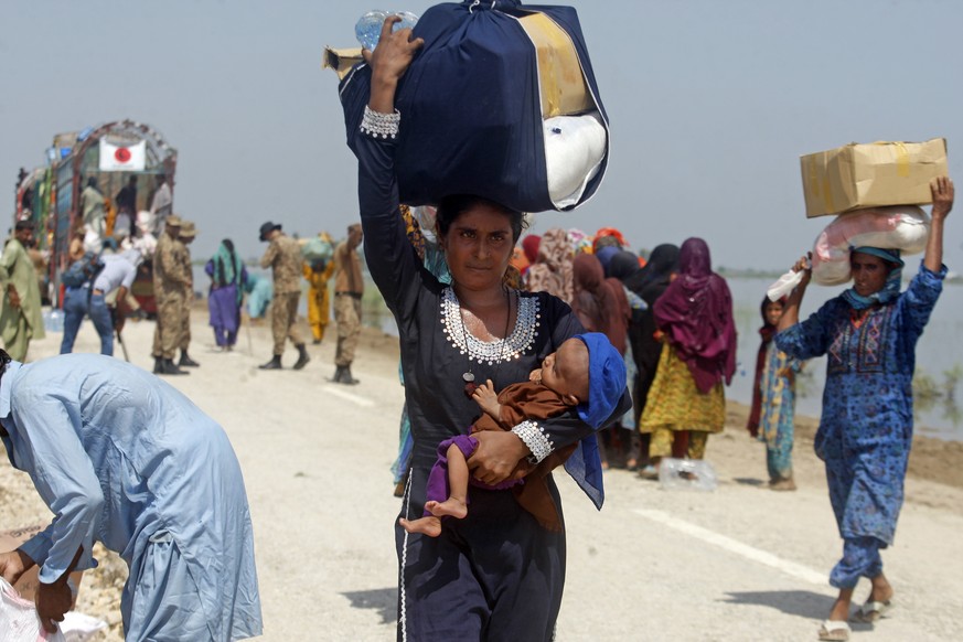 FILE - Victims of regional floods from monsoon rains receive emergency aid from the Pakistan Army in Qambar Shahdadkot district of Sindh province, Pakistan, September 9, 2022. (AP Photo/Fareed Khan, F...