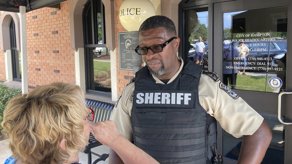 Henry County Sheriff Reginald Scandrett talks to a local resident on Sunday, July 16, 2023, in Hampton, Ga. Scandrett and other law enforcement officials announced that officers shot and killed Andre  ...