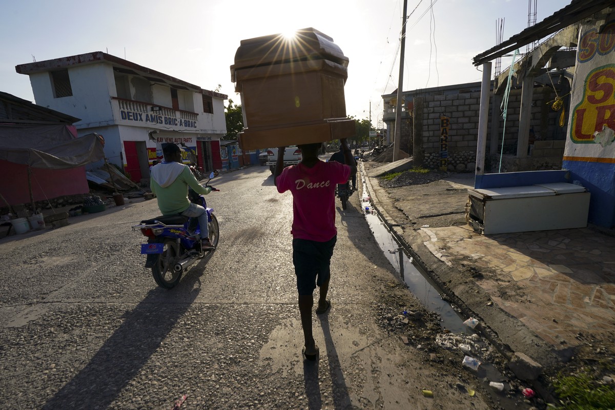 A worker carries a coffin form a storage depot to a funeral home in Les Cayes, Haiti, Wednesday, Aug. 18, 2021. A 7.2-magnitude earthquake struck the southwestern part of the hemisphere's poorest ...