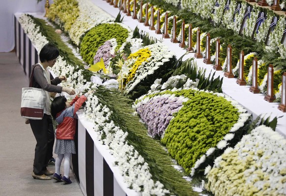 Angehörige legen Blumen an einem provisorischen Altar in Ansan nieder.&nbsp;