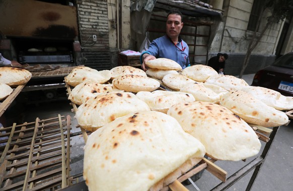 epa09826542 An Egyptian man buys bread from a bakery in Cairo, Egypt, 15 March 2022. The Egyptian government said the country is expecting in the coming days a shipment of about 126,000 tons of wheat  ...