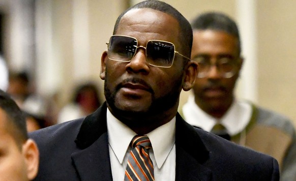 FILE - Musician R. Kelly, center, leaves the Daley Center after a hearing in his child support case on May 8, 2019, in Chicago. Closing arguments are scheduled Monday, Sept. 12, 2022 for R. Kelly and  ...