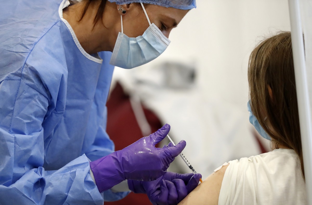 epa09538935 A Romanian woman gets a Pfizer vaccine dose from a volunteer nurse at a Covid-19 Marathon Vaccination For Life center organized at Children Palace venue in Bucharest, Romania, 22 October 2 ...