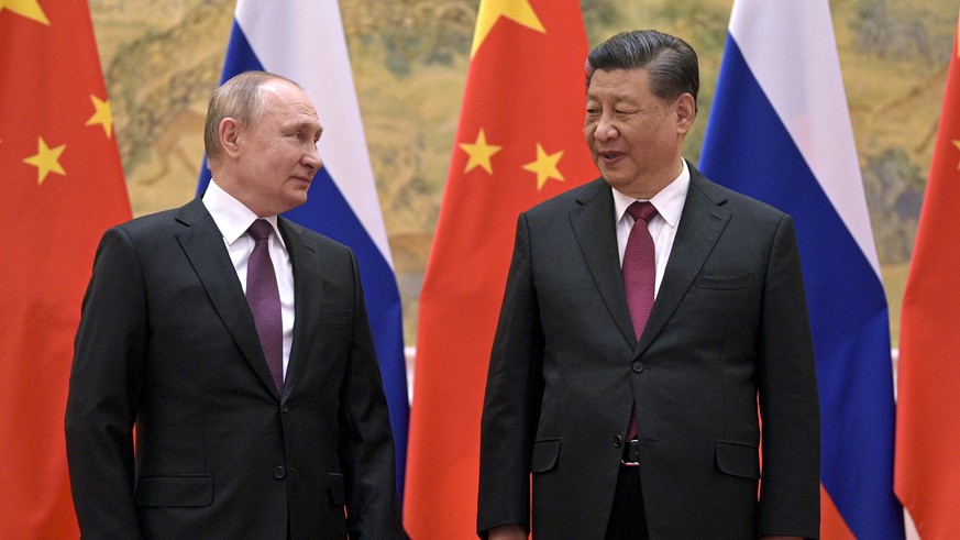 FILE - Chinese President Xi Jinping, right, and Russian President Vladimir Putin talk to each other during their meeting in Beijing, Feb. 4, 2022. China on Thursday, March 3, 2022, denounced a report  ...