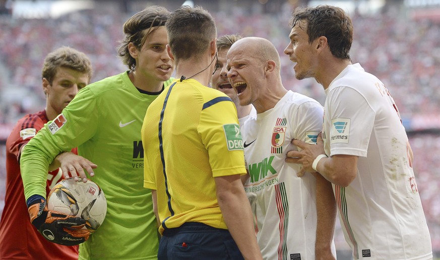 Entsetzte Augsburger: Der Schweizer Goalie Marwin Hitz und seine Kollegen bestürmen Schiedsrichter-Assistent Robert Kempter.