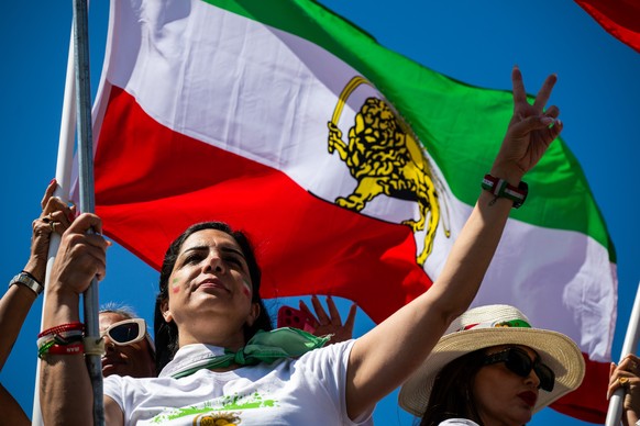 A woman holds up a peace sign during a protest in reaction to FIFA's ban of Iran's pre-revolutionary flag inside World Cup stadiums Sunday, June 7, 2026, in Inglewood, Calif. (AP Photo/Benja ...