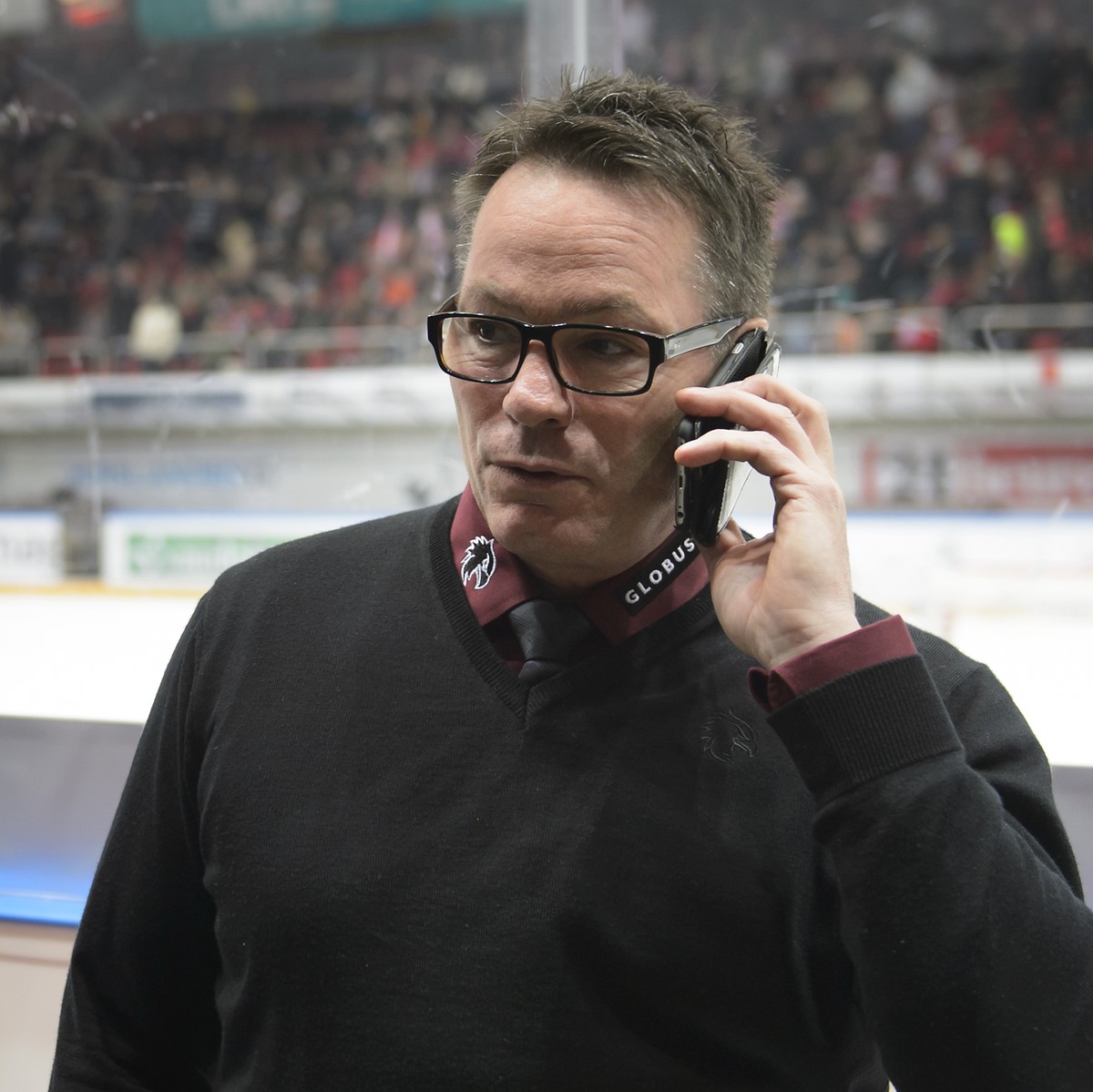 L'entraineur genevois Chris McSorley, parle au telephone apres l'annulation de la rencontre suite a un ecran geant lumineux au milieu de la patinoire, lors du match du championnat suisse de  ...