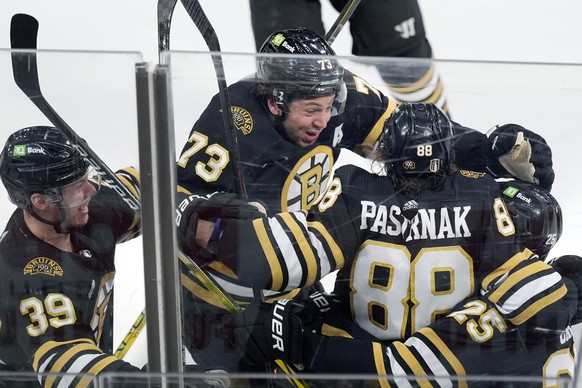 Boston Bruins&#039; David Pastrnak (88) celebrates his goal with Morgan Geekie (39), Charlie McAvoy (73) and Brandon Carlo (25) in overtime during Game 7 of an NHL hockey Stanley Cup first-round playo ...