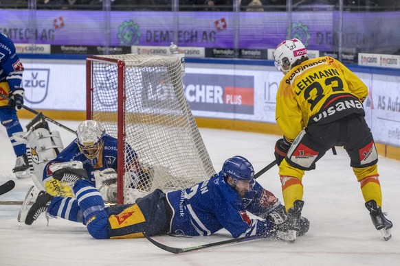 Marco lehmann, rechts, von Bern im Spiel gegen Lukas bengtsson, mitte, und Torhueter Leonardo Genini, links, von Zug beim Eishockey Meisterschaftsspiel der National League zwischen dem EV Zug und dem  ...