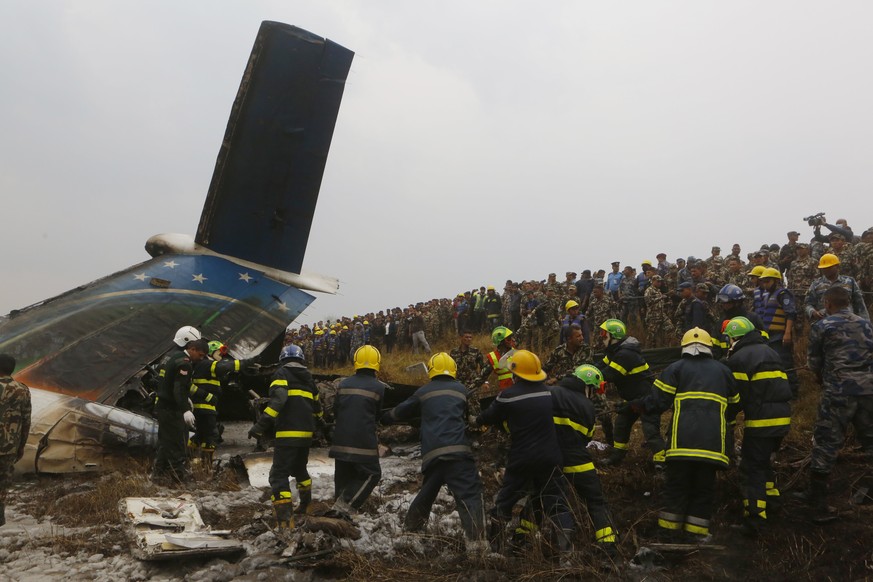 Nepalese rescuers work after a passenger plane from Bangladesh crashed at the airport in Kathmandu, Nepal, Monday, March 12, 2018. A passenger plane carrying 71 people from Bangladesh crashed and burs ...