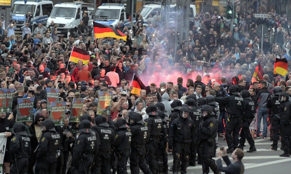Protesters light fireworks during a far-right demonstration in Chemnitz, Germany, Monday, Aug. 27, 2018 after a man has died and two others were injured in an altercation between several people of &qu ...