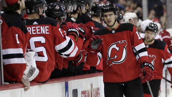 New Jersey Devils center Nico Hischier, right front, of Switzerland, skates by the bench after scoring a goal against the Detroit Red Wings during the first period of an NHL hockey game Wednesday, Dec ...