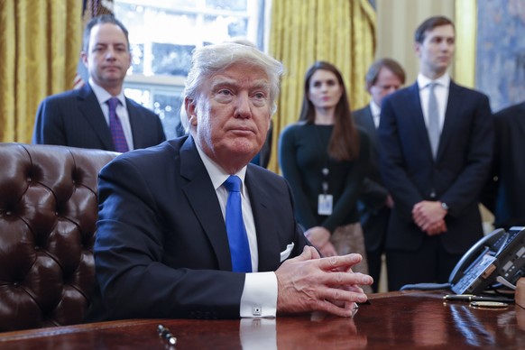 epa05747181 US President Donald Trump (F), with White House chief of staff Reince Pribus (L), White House Communications Director Hope Hicks (2L) and Senior Advisor Jared Kushner (R), after signing fi ...