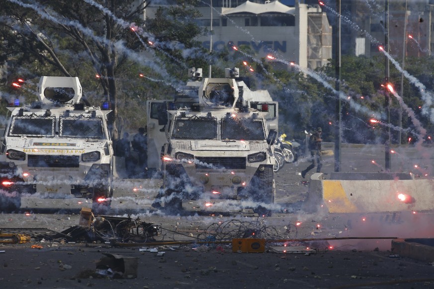Fireworks launched by opponents of Venezuela&#039;s President Nicolas Maduro land near Bolivarian National Guard armored vehicles loyal to Maduro, during an attempted military uprising in Caracas, Ven ...