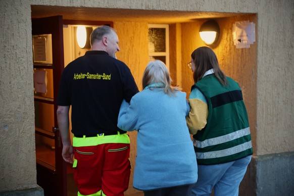 epa12628861 Helpers bring an elderly woman into an emergency shelter at a school gym during a power outage in southwest Berlin, Germany, 05 January 2026. According to state-owned operator Stromnetz Be ...