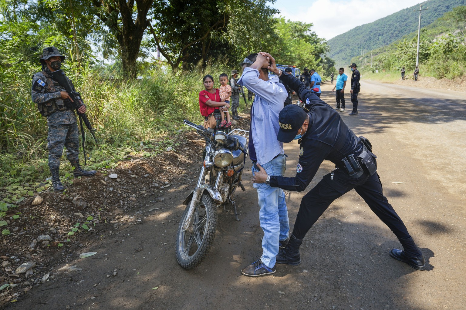 A man is frisked by police at a check point in El Estor in the northern coastal province of Izabal, Guatemala, Monday, Oct. 25, 2021. The Guatemalan government has declared a month-long, dawn-to-dusk  ...
