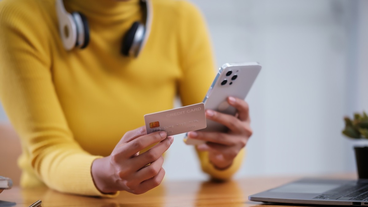Bezahlen mit Smartphone und Kreditkarte (Symbolbild).