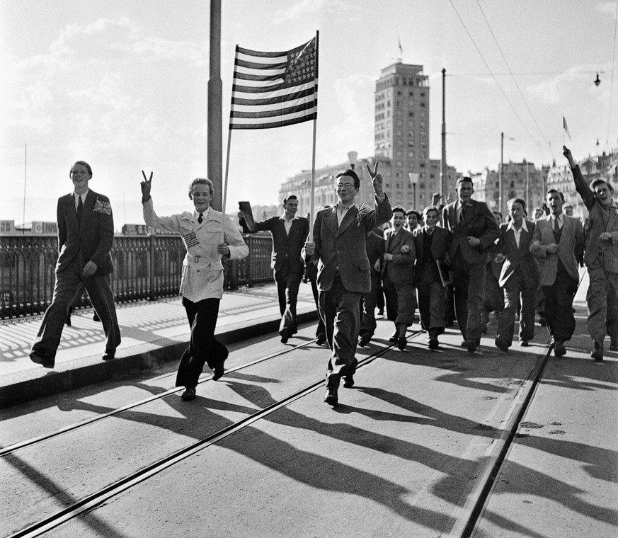 Eine Gruppe zieht am 8. Mai 1945, dem Tag der Kapitulation Deutschlands, mit einer amerikanischen Flagge durch die Strassen von Lausanne und feiert das Kriegsende in Europa. (KEYSTONE/PHOTOPRESS-ARCHI ...