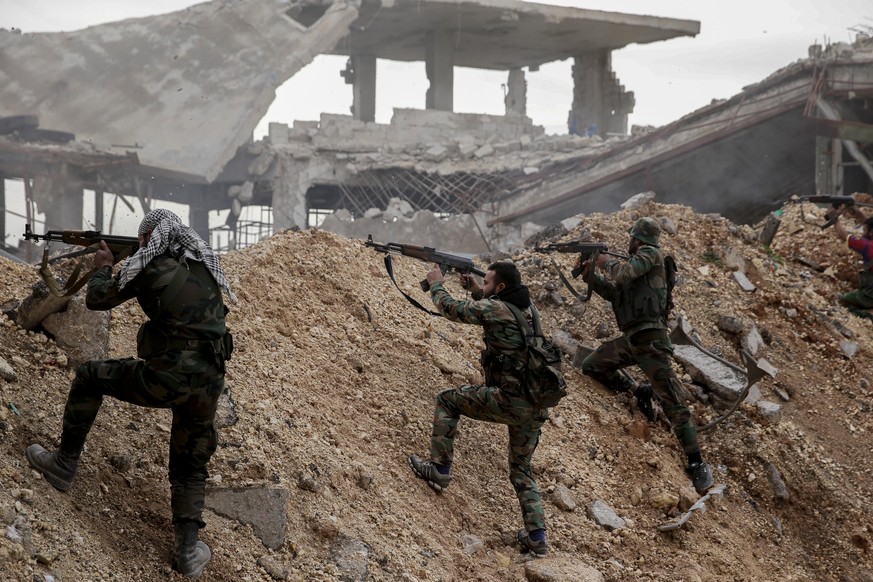 FILE - Syrian army soldiers fire their weapons during a battle with rebel fighters at the Ramouseh front line, east of Aleppo, Syria, Monday, Dec. 5, 2016. Tuesday, March 15, 2022 marks the 11th anniv ...