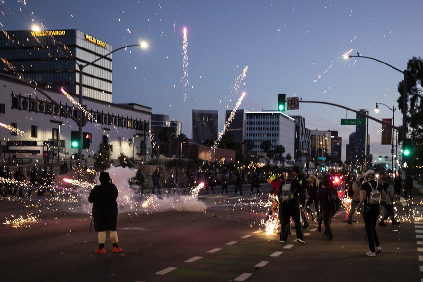 epa08455622 A flashbang explodes next to protesters as they face the police on Rodeo Drive during curfew as thousands of protesters take the street to demonstrate following the death of George Floyd, ...