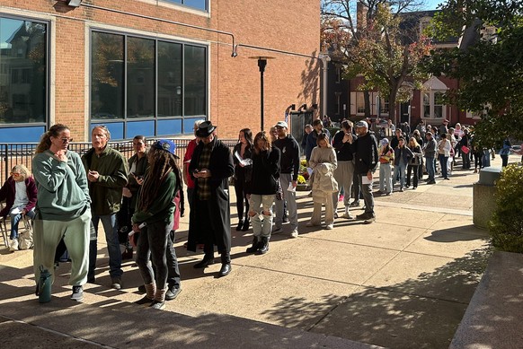 People wait in line outside the Bucks County government building to apply for an on-demand mail ballot on the last day to request one in Doylestown, Pa., Tuesday, Oct. 29, 2024. (AP Photo/Mike Catalin ...