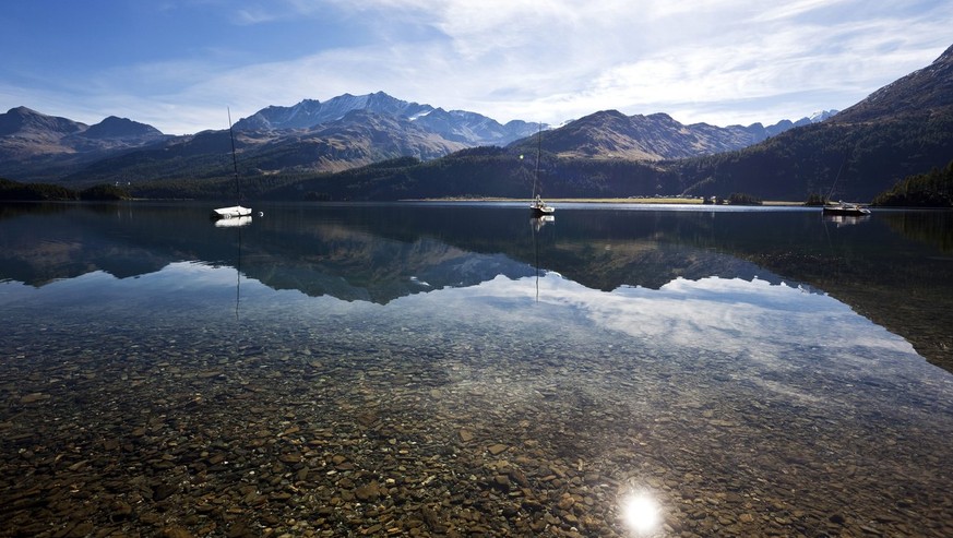 Die Bergkette des Piz Corvatsch mit den Seitentaeler Val Fex und Val Fedox spiegeln sich am Mittwoch, 22. September 2010, im spiegelglatten Silsersee in Plaun da Lej im Oberengadin. (KEYSTONE/Arno Bal ...