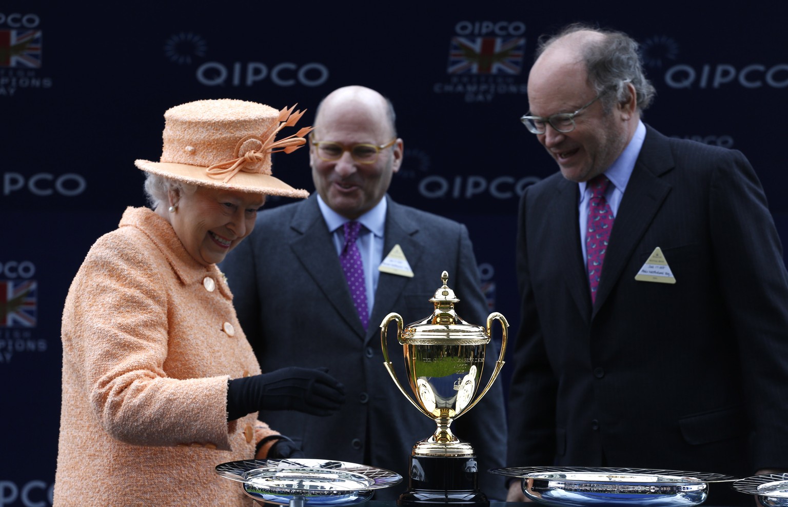 ASCOT, ENGLAND - OCTOBER 17: Queen Elizabeth II presents the trophy to owners Alain Wertheimer and Gerard Wertheimer, after their horse Solow won the Queen Elizabeth II Stakes Race run during the QIPC ...