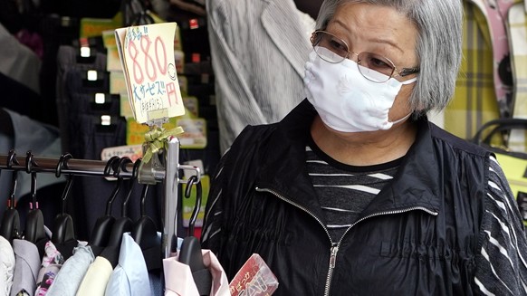 epa08340658 An elderly woman wearing a face mask shops at a clothing store at Sugamo district in Tokyo, Japan, 03 April 2020. Despite the rise of infection cases, Japan&#039;s Prime Minister Shinzo Ab ...