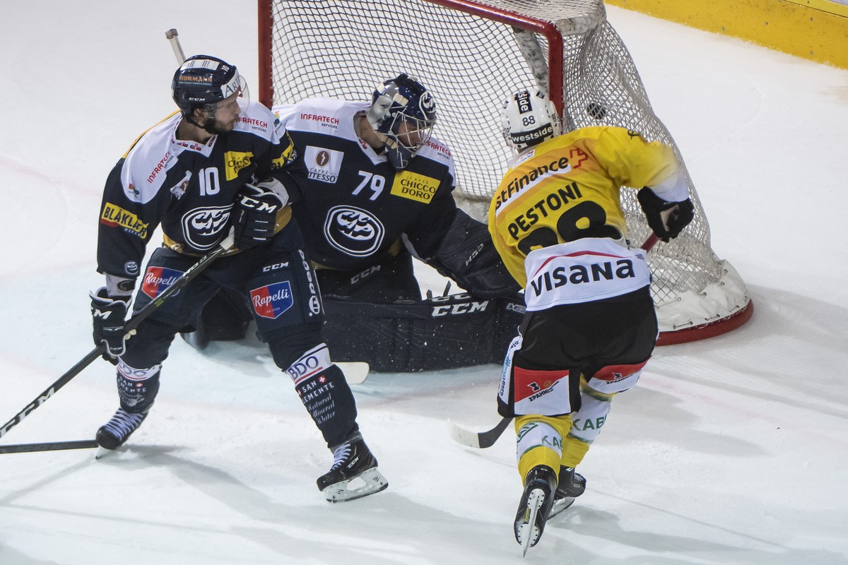 From right, Bern's player Inti Pestoni, scores the 1:3 against Ambri's goalkeeper Daniel Manzato and Ambri's player Bryan Flynn, during the preliminary round game of National League A ( ...