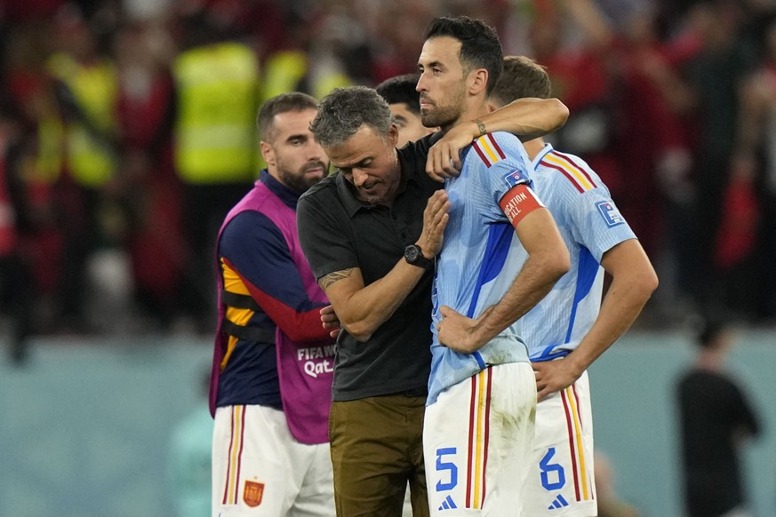 Spain's head coach Luis Enrique, left, embraces Sergio Busquets after the penalty shootout at the World Cup round of 16 soccer match between Morocco and Spain, at the Education City Stadium in Al Rayy ...