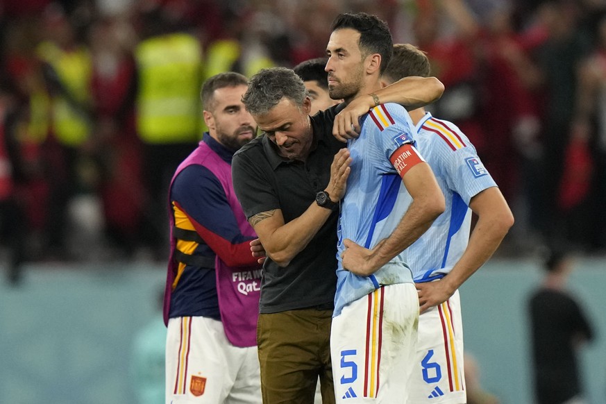 Spain&#039;s head coach Luis Enrique, left, embraces Sergio Busquets after the penalty shootout at the World Cup round of 16 soccer match between Morocco and Spain, at the Education City Stadium in Al ...