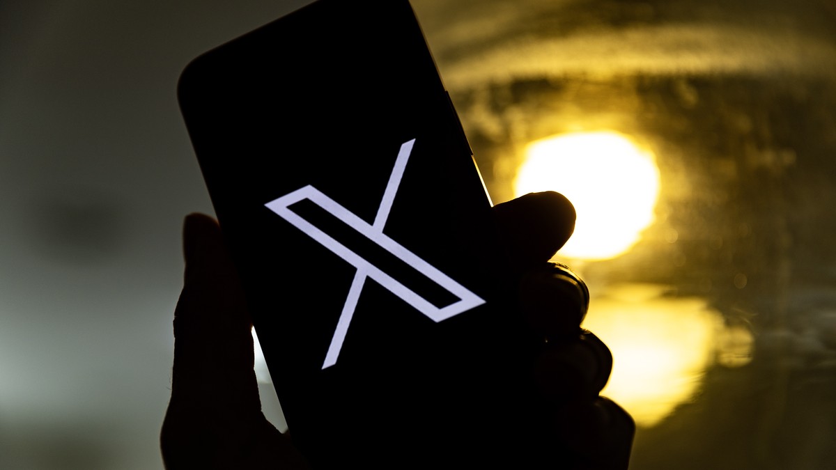 epa10772440 An illustration pictures shows a user holding a mobile phone displaying the 'X' logo, in Los Angeles, California, USA, 27 July 2023. Twitter announced on 23 July that it will reb ...
