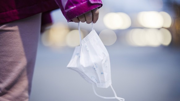 Eine Primarschuelerin haelt eine Kinder Maske auf einem Pausenplatz einer Schule, aufgenommen am Montag, 3. Januar 2022 in Zuerich. Die Maskentragpflicht im Kanton Zuerich wird mit dem Schulstart nach ...