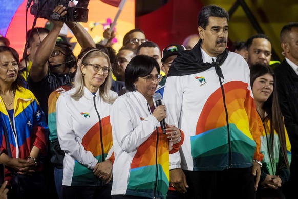 epa11010185 The vice president of Venezuela Delcy Rodriguez (C) speaks next to the president of Venezuela Nicolas Maduro (R), and the first lady Cilla Flores (L), during a celebration event after the  ...