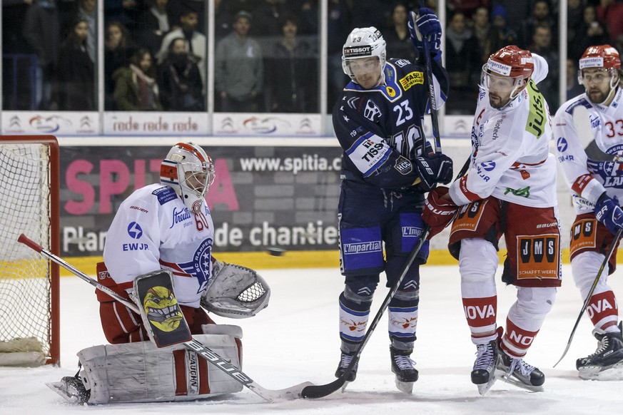 Lakers&#039; goaltender Melvin Nyffeler, left, saves a puck past La Chaux-de-Fonds&#039; forward Daniel Carbis, center and Lakers&#039; defender Cyrill Geyer, right, during the fifth leg of the Playof ...