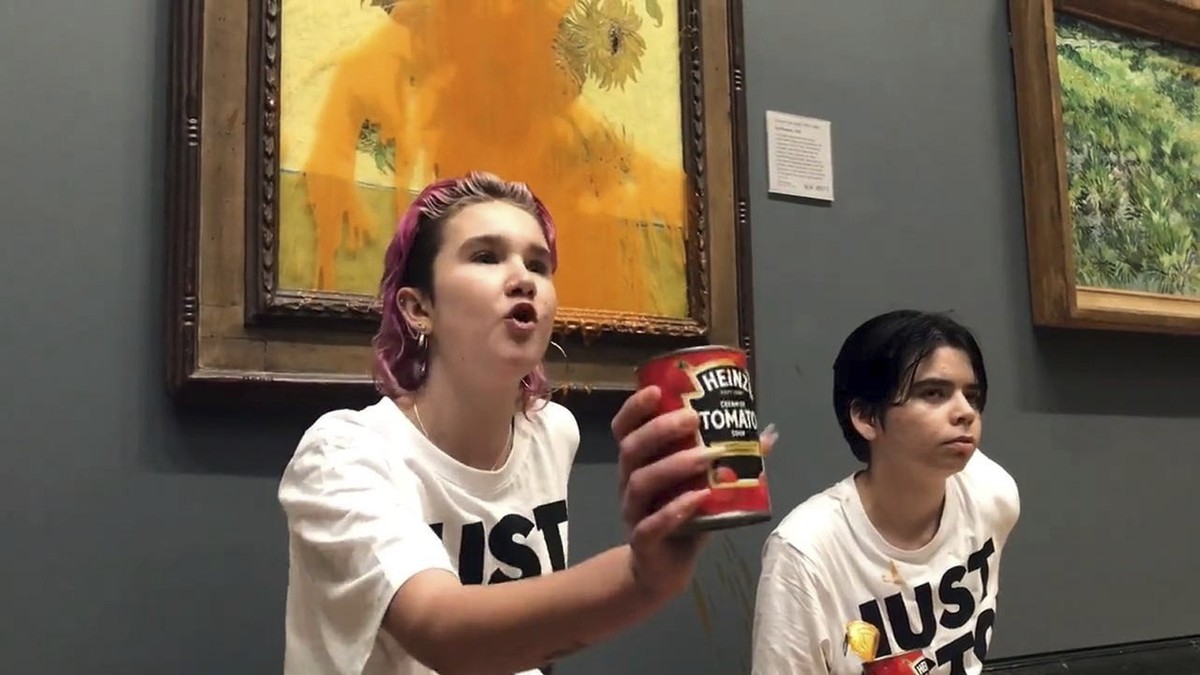 Handout photo issued by Just Stop Oil of two protesters who have thrown tinned soup at Vincent Van Gogh's famous 1888 work Sunflowers at the National Gallery in London, Friday Oct. 14, 2022. The  ...