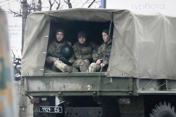 Ukrainian soldiers ride in a military vehicle in Mariupol, Ukraine, Thursday, Feb. 24, 2022. Russian troops launched their anticipated attack on Ukraine on Thursday, as President Vladimir Putin cast a ...