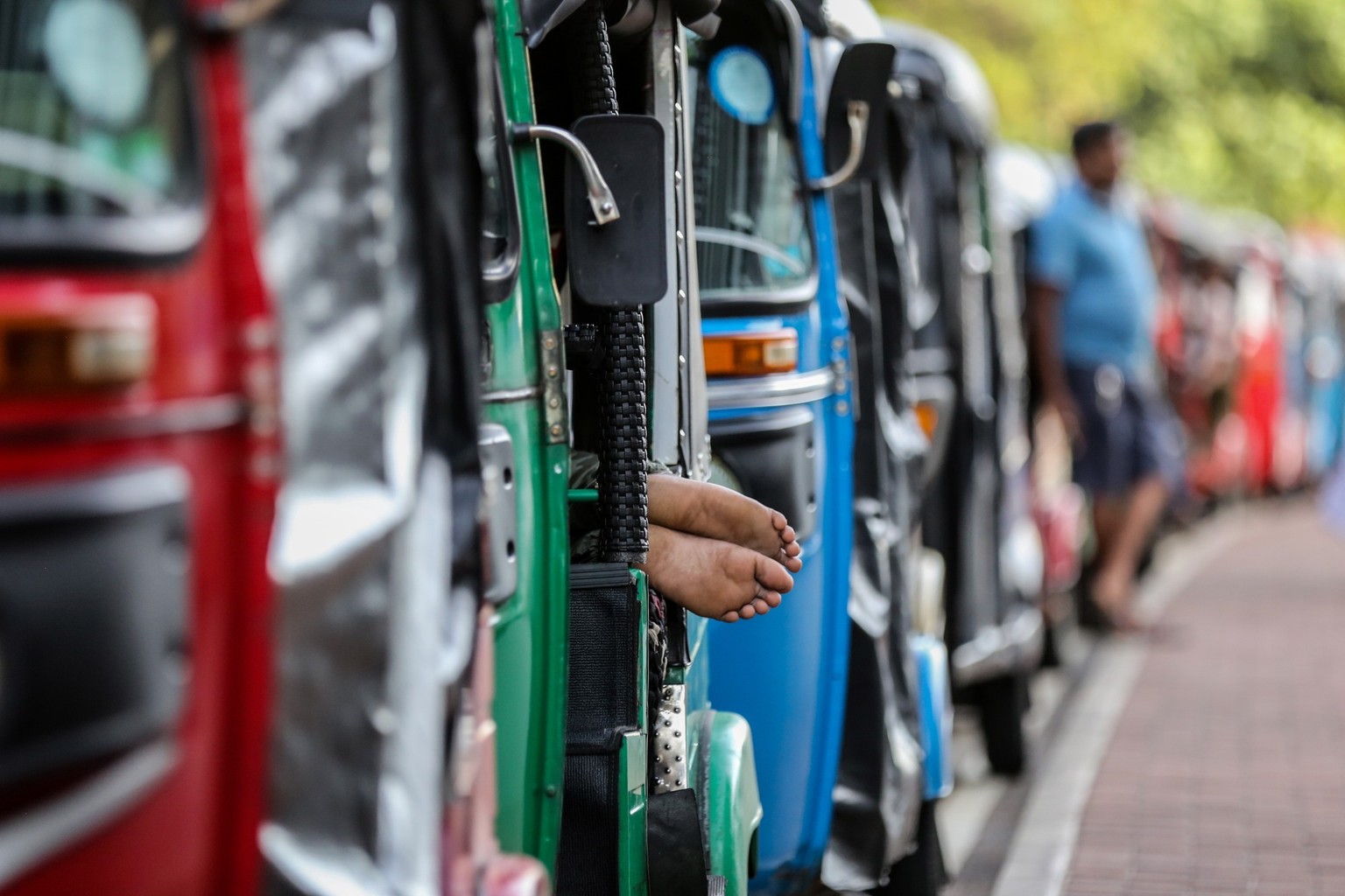 epa10036289 Auto-rickshaw drivers wait in a queue to get fuel from a gas station amid a fuel shortage in Colombo, Sri Lanka, 27 June 2022. Sri Lankans are experiencing the longest fuel queues in their ...
