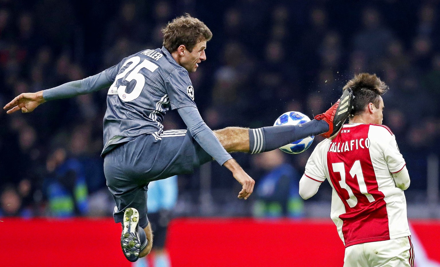 epa07227146 Thomas Mueller (L) of Bayern Munich fouls Nicolas Tafliafico (R) of Ajax during the UEFA Champions League Group E soccer match between Ajax Amsterdam and Bayern Munich in Amsterdam, Nether ...