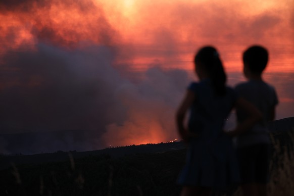 epa12271461 Children watch the fire in Arouca, Portugal, 29 July 2025. The fire that has been raging for more than 24 hours in Arouca, in the district of Aveiro, has three active fronts and has alread ...